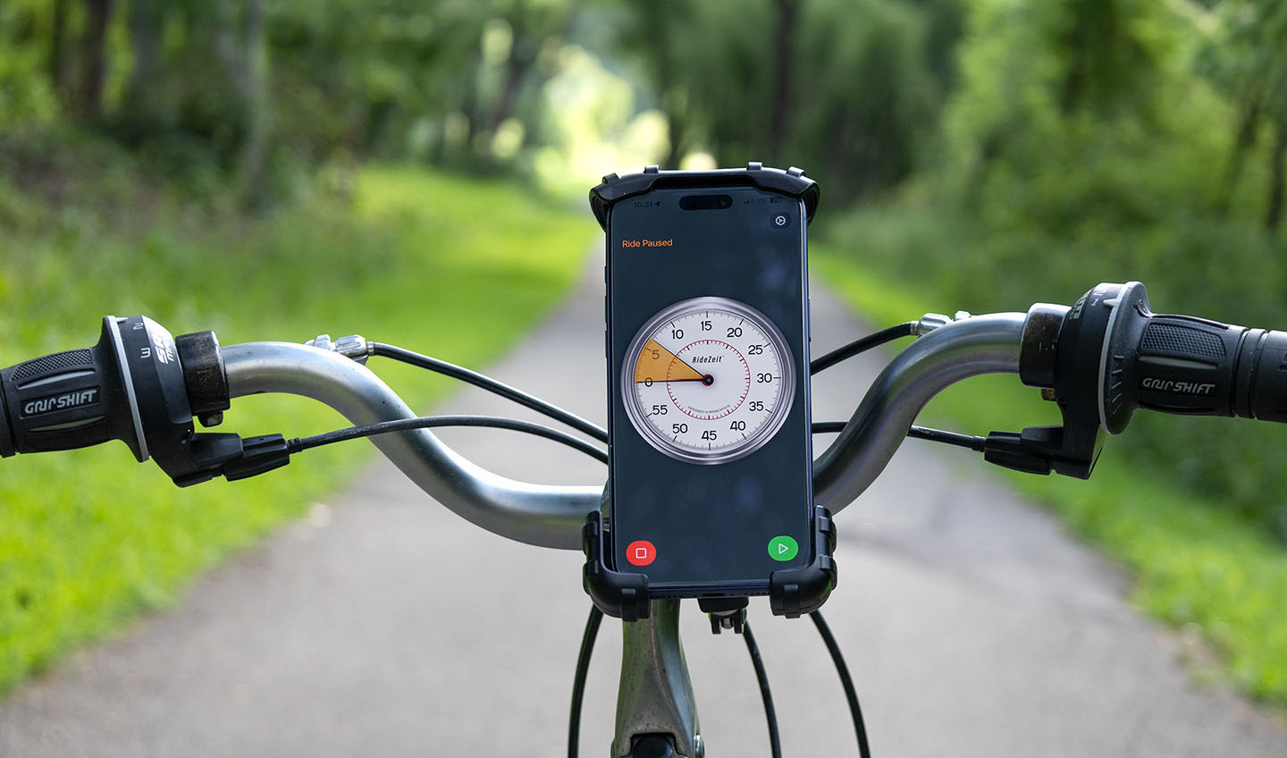 Photo showing an iPhone mounted to a bike with RideZeit app showing a watch face with performance indicators
